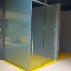 sklenená stena s posuvnými dverami z matného skla