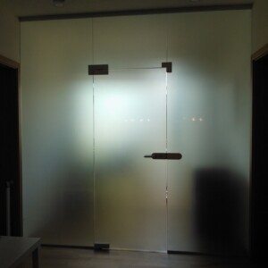 sklenená stena s otočnými dverami z matného skla