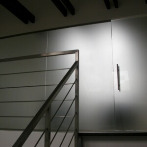 sklenená stena s otočnými dverami z matného skla