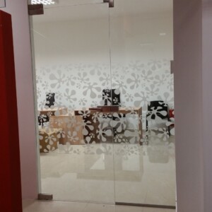 sklenená stena s otočnými dverami z číreho skla so vzorom