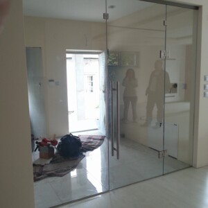 sklenená stena s otočnými dverami z číreho skla