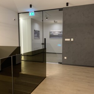 sklenená stena s otočnými dverami z šedého skla