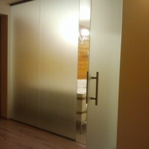 sklenená stena s otočnými dverami z matného skla