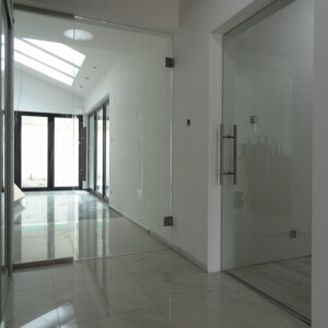 sklenená stena s otočnými dverami z číreho skla