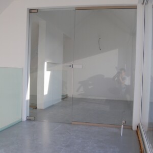 sklenená stena s otočnými dverami z číreho skla