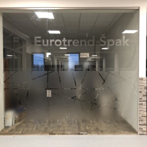sklenená stena s otočnými dverami s polepom