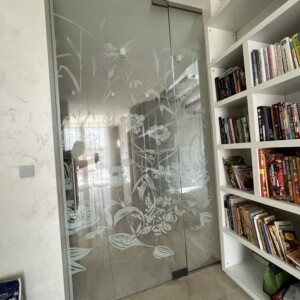 sklenená stena s otočnými dverami z číreho skla s polepom