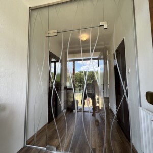 sklenená stena s otočnými dverami z číreho skla s polepom