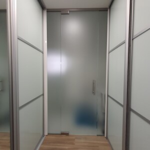 sklenená stena s otočnými dverami z matného skla