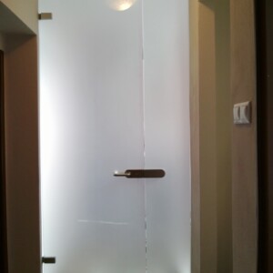 sklenená stena s otočnými dverami z matného skla