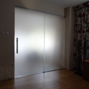 sklenená stena s posuvnými dverami z matného skla