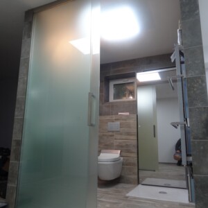 sklenená stena s posuvnými dverami z matného skla