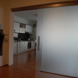 sklenená stena s posuvnými dverami z matného skla