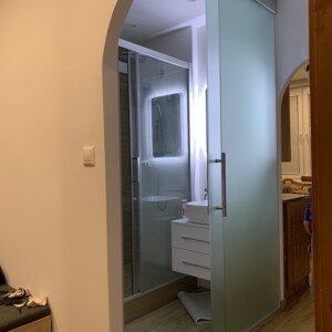 sklenená stena s posuvnými dverami z matného skla