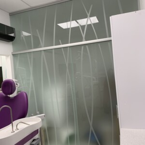 sklenená stena s posuvnými dverami z matného skla s polepom