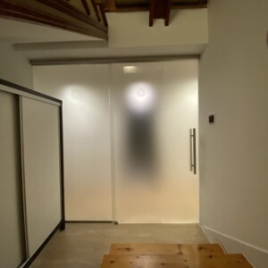 sklenená stena s posuvnými dverami z matného skla