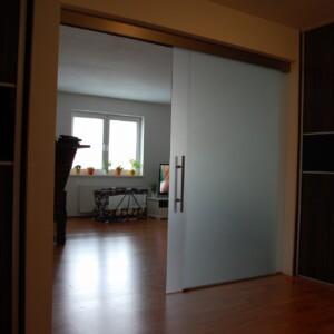 sklenená stena s posuvnými dverami z matného skla