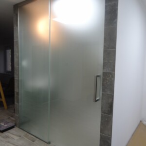 sklenená stena s posuvnými dverami z matného skla