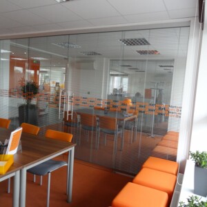 sklenená stena s posuvnými dverami z číreho skla z polepom