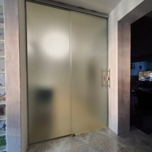 sklenená stena s posuvnými dverami z matného skla
