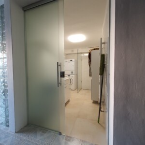 sklenená stena s posuvnými dverami z matného skla