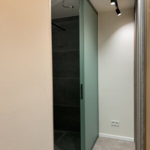 sklenená stena s posuvnými dverami z matného skla