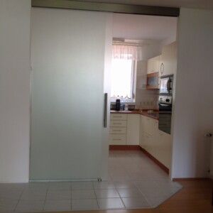 sklenená stena s posuvnými dverami z matného skla