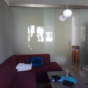 sklenená stena s posuvnými dverami z matného skla