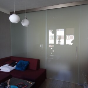 sklenená stena s posuvnými dverami z matného skla