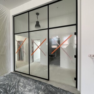 sklenená stena s otočnými dverami v hliníkovom čiernom ráme